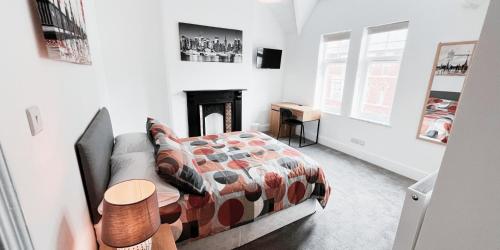 a bedroom with a bed and a fireplace at Large Room in Modern House near Nottingham in Nottingham