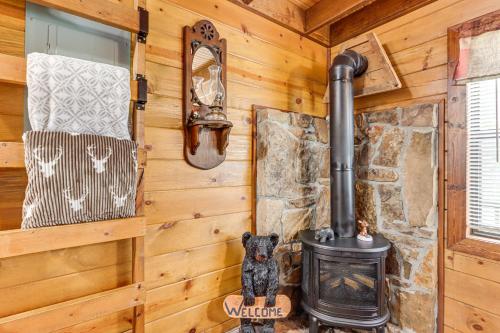 a fireplace in a log cabin with a stove at Cozy Pelsor Cabin with Mountain and Valley Views! in Lurton