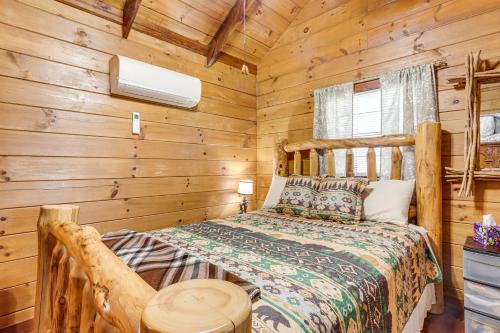 a bedroom with a bed in a log cabin at Cozy Pelsor Cabin with Mountain and Valley Views! 