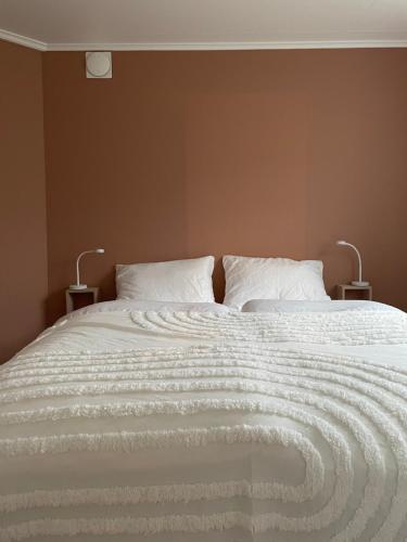 a bedroom with a bed with two lamps on it at Cozy apartment with a view in Tromsø