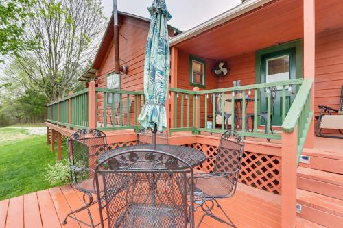 a patio with a table and chairs on a deck at Cozy Pelsor Cabin with Mountain and Valley Views! in Lurton