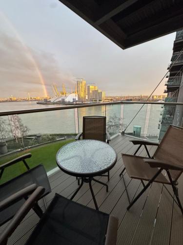 a balcony with a table and chairs and a rainbow at Luxury apartment in Canary Wharf in London