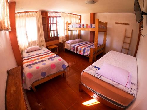 a bedroom with two beds and a bunk bed at HOSPEDAJE SCHASCA in Oxapampa