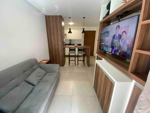 a living room with a couch and a flat screen tv at Monte Carmel in Ribeirão Preto