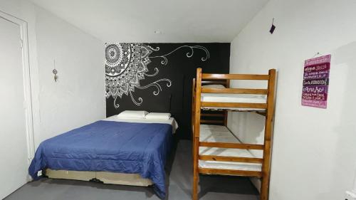 a bedroom with a bunk bed and a ladder at Hostel Caiçara Maresias in São Sebastião