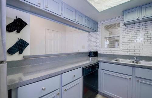 a kitchen with white cabinets and a sink at 37A- Casa Grande Modern Condo 1bd w Heated Pool in Casa Grande