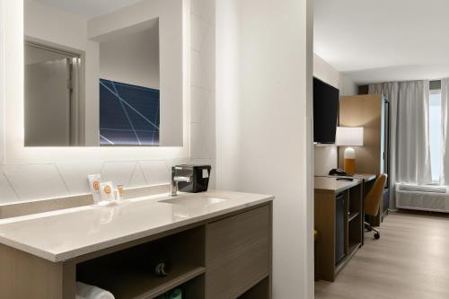 a bathroom with a sink and a desk in a room at Comfort Inn Conroe in Conroe