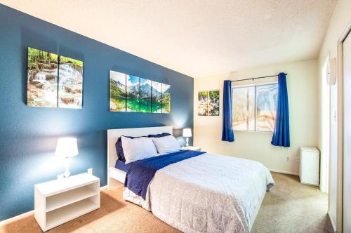 78- Modern Casa Grande Desert Paradise heated pool في كازا غراندي: غرفة نوم زرقاء مع سرير وجدران زرقاء