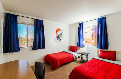 1 Schlafzimmer mit 2 Betten, einem Tisch und blauen Vorhängen in der Unterkunft 88 Casa Grande 3bd 2b modern comfort heated pool in Casa Grande