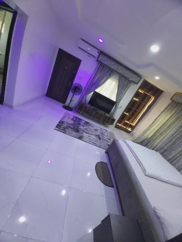 a living room with purple lighting and a couch at Sammy's Place in Lekki