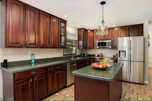 a kitchen with wooden cabinets and a bowl of fruit on the counter at Large Private House on 5 Wooded Acres. Total Privacy! in Hackettstown