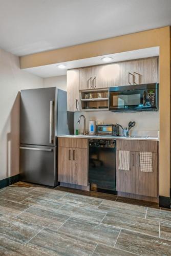 a kitchen with wooden cabinets and a stainless steel refrigerator at Tempe Studio Apartment 2 in Tempe