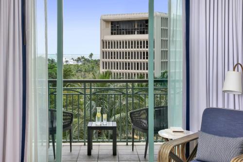 een kamer met een balkon met stoelen en een tafel bij The Ritz-Carlton Coconut Grove, Miami in Miami