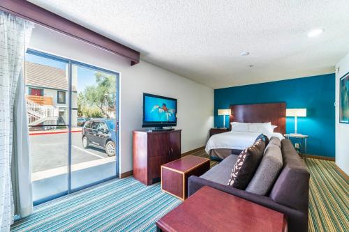 Habitación de hotel con cama y sofá en Metro PHX Promotional Studio, en Phoenix