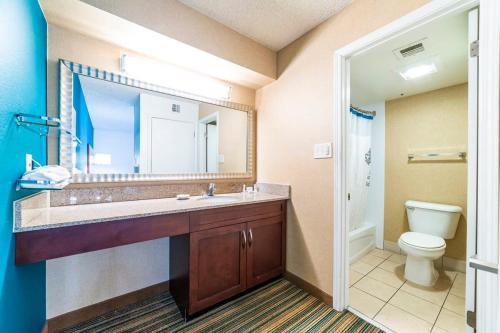 a bathroom with a sink and a toilet and a mirror at Metro PHX All Inclusive PROMO in Phoenix