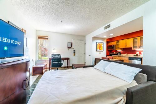 a bedroom with a large bed and a kitchen at Metro PHX All Inclusive PROMO in Phoenix