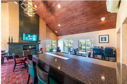 a large room with a bar with chairs and a television at Metro PHX All Inclusive PROMO in Phoenix
