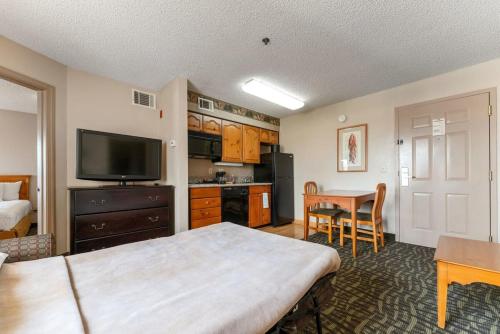 a room with a bed and a table with a television at Scottsdale 2 bd 2 ba furnished apt 4 full beds in Scottsdale