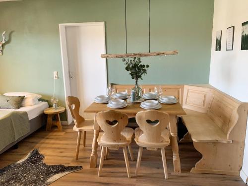 a dining room with a wooden table and chairs at Gesamte Ferienwohnung Bergblick 6 Pers Balkon Garten Hund Ski Unterkunft Luftkurort Oberreute nähe Buchenegger Wasserfälle Eistobel in Oberreute