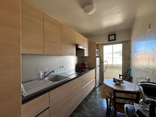 une cuisine avec un évier et une table à l'intérieur dans l'établissement A017-Charmant 2 pièces à 200M de la Croisette, à Cannes