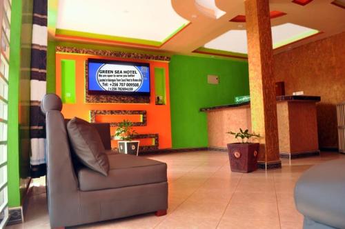a lobby with a couch and a television in a building at Green Sea Hotel in Kalangala