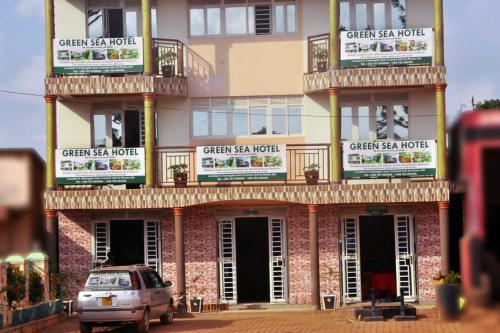 a building with a car parked in front of it at Green Sea Hotel in Kalangala