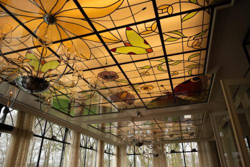 a stained glass ceiling with butterflies on it at Kasteel De Vanenburg in Putten