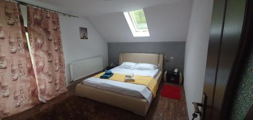 ein kleines Schlafzimmer mit einem Bett und einem Fenster in der Unterkunft Casa Yna in Horezu
