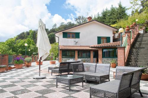 een patio met een tafel en stoelen en een parasol bij Bed&Breakfast Bella Vita in Bracco