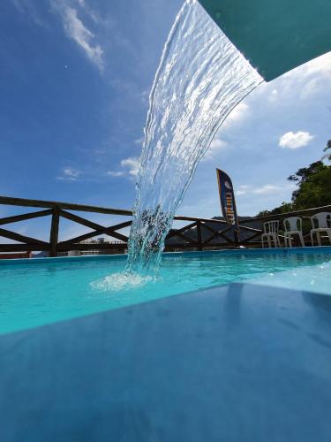 a fountain in the middle of a swimming pool at Pousada Tuiuiu in Angra dos Reis