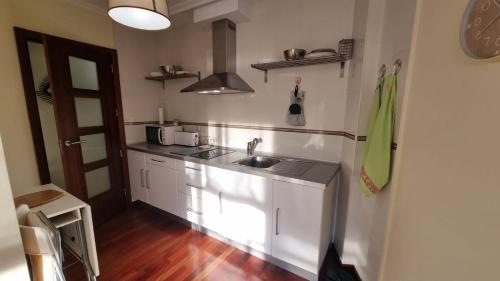 a kitchen with white cabinets and a sink at Apartamento 1 dormitorio 4 personas en El Grove in O Grove