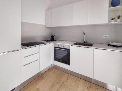 a white kitchen with white cabinets and a sink at Villa Ina Lux in Fontane Bianche
