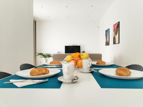 a table with plates of food and fruit on it at Villa Ina Lux in Fontane Bianche