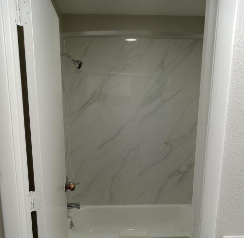 a bathroom with a white marble shower stall at RELAX INN in Rockingham