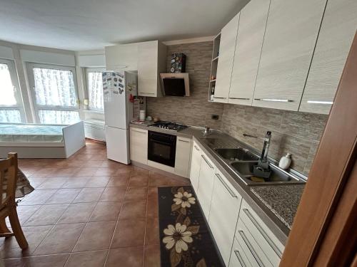 een keuken met witte kasten en een wastafel bij Pina’s home in Trieste