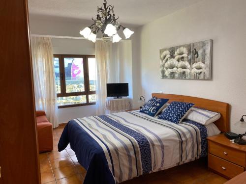 Un dormitorio con una cama con almohadas azules y una ventana en Casa Roji, en Loredo