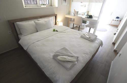 a large white bed with two towels on top of it at Central Luxury Flat 1 in Chios