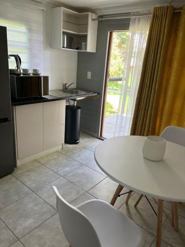 a kitchen with a white table and chairs and a table at Miami Gardens in Roodepoort