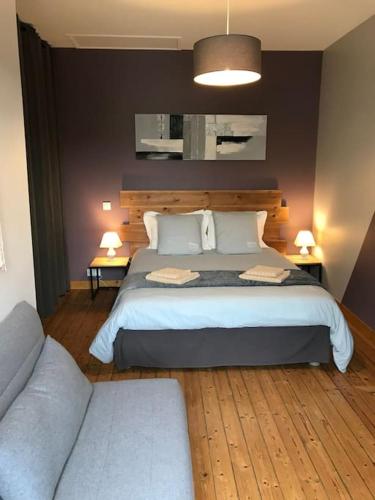 une chambre avec un grand lit et un canapé dans l'établissement L’Écho des Vagues, Cherbourg en Cotentin, à Cherbourg en Cotentin