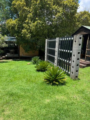 a fence in a yard with plants in the grass at Miami Gardens in Roodepoort