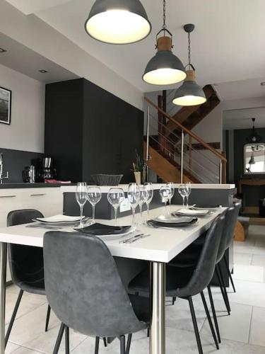 - une table à manger avec des chaises et des verres à vin dans l'établissement L’Écho des Vagues, Cherbourg en Cotentin, à Cherbourg en Cotentin