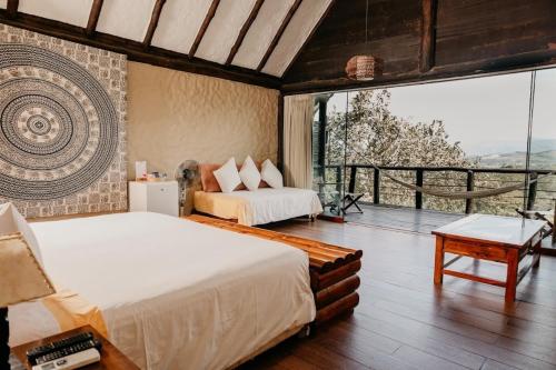 a bedroom with two beds and a large window at HOTEL RUSTICA TARAPOTO in Tarapoto