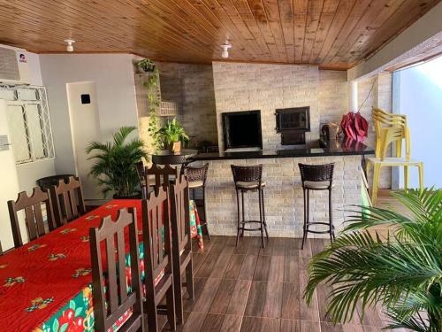 uma sala de estar com um bar com cadeiras e um balcão em Casa com Piscina em Região Nobre de Cascavel em Cascavel