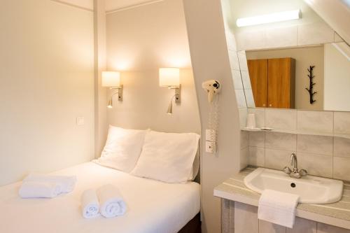 Habitación de hotel con cama y lavabo en Hôtel Marignan en París