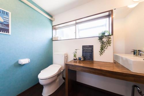 a bathroom with a toilet and a sink and a window at ガジュマルの庭～itoman in Ō