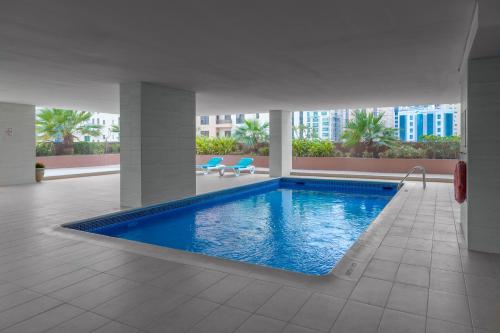 a large swimming pool in a building at Afaq Tower in Manama