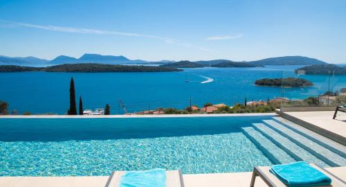 a swimming pool with a view of a body of water at Apaggio Villas in Nydri