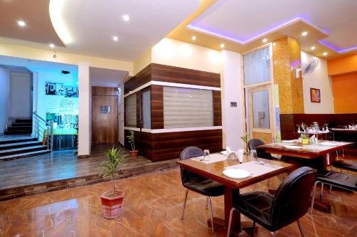 a restaurant with tables and chairs in a room at TRP VIVEK CONTINENTAL in Gwalior