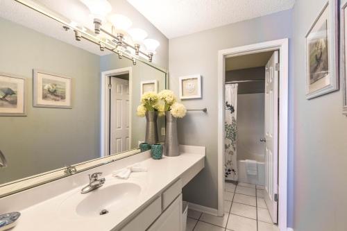 La salle de bains est pourvue d'un lavabo et d'un miroir. dans l'établissement Phoenix Vi 1210, à Orange Beach