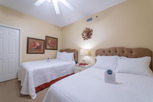 - une chambre avec 2 lits avec des draps blancs et un panneau sur eux dans l'établissement Phoenix Vi 1210, à Orange Beach